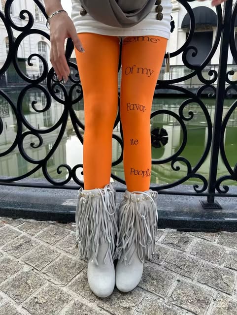 Orange printed tights styled with fringe boots