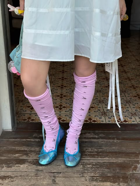 Pink knee-high socks styled with blue shoes